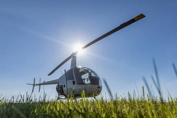 Küçük Robinson R22 ışık yarar helikopter ot Havaalanı üzerinde park etmiş. Biri dünyanın en popüler ışık ikiz bıçaklar ve tek motorlu helikopterler