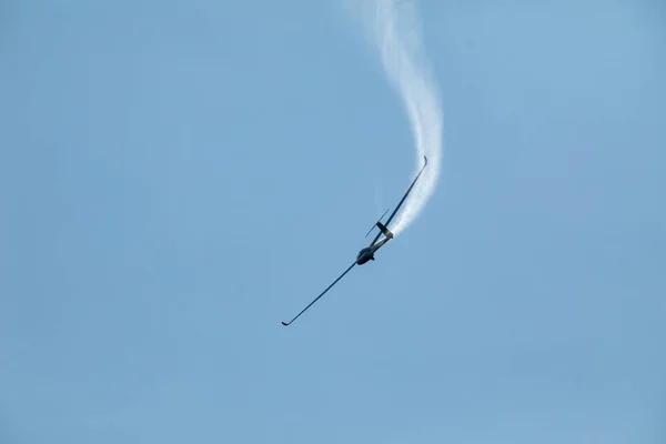 青い空を飛んでいるグライダーは着陸の前に水を排出します。. — ストック写真