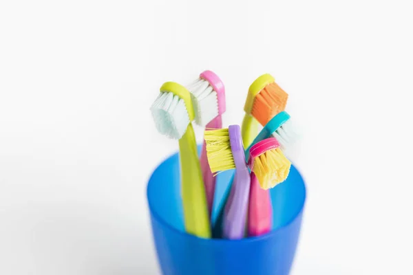 New and used color ultra fine toothbrushes in colorful glasses. — Stock Photo, Image