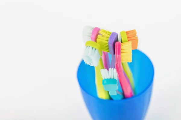 Nieuwe en gebruikte kleur ultra fijne tandenborstels in kleurrijke glazen. — Stockfoto