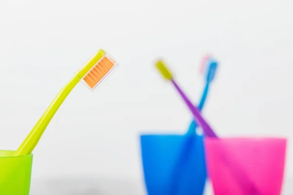 New color ultra fine toothbrushes in colorful glasses. Dental In — Stock Photo, Image