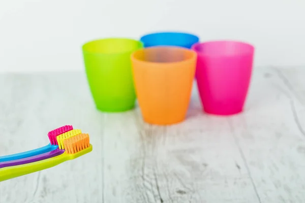 New color ultra fine toothbrushes in colorful glasses. Dental In — Stock Photo, Image