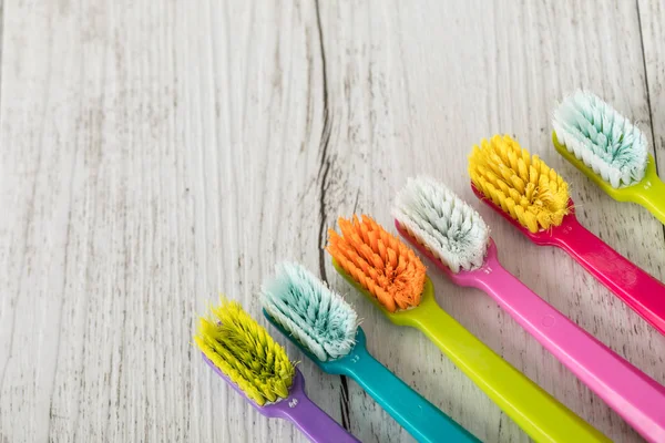 Cepillos de dientes nuevos y usados de color ultra fino en la mesa. Industria dental. varios tipos de cepillos de dientes. Hermoso concepto de sonrisa. Blanqueamiento. Cuidado dental. Concepto saludable de los dientes . — Foto de Stock