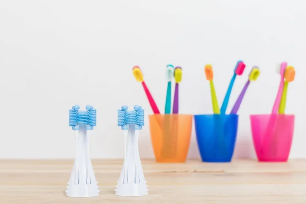 Ultra fine toothbrushes in colorful glasses and electric modern tooth brush closeup. Dental Industry. various types of toothbrushes. Beautiful smile concept. Tooth care. Teeth healthy concept — Stock Photo, Image