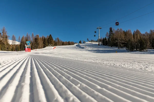 Dolomitas, área de esqui com belas encostas e céu azul. Esvaziar pista de esqui no inverno em um dia ensolarado. Preparar pista de esqui, Alpe di Lusia, Itália — Fotografia de Stock