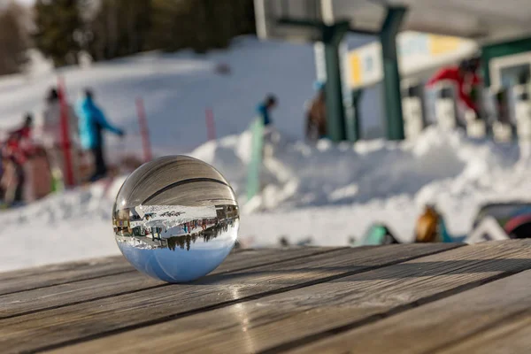 Bola de vidro em uma mesa de madeira nas Dolomitas. Uma vista sobre o globo à nossa volta. Dia ensolarado em Dolomites. Alpe di Lusia.. Itália — Fotografia de Stock