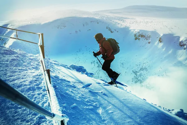 トレッキング ポールがスノーシューの男は山の雪です。雪のパスにスノーシューを持つ男。スノーシュー、バックカントリー靴の最も汎用性と最高レベルのパフォーマンス. — ストック写真