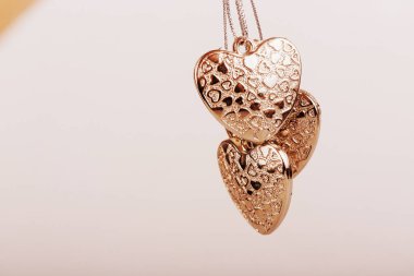 Zincirlenmiş kalp. Üç altın kalp. Sevgililer Günü tatili. Kızlar ve erkekler için altın kalpler.