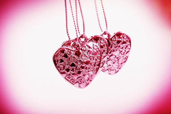 Heart on chain. Three pink hearts. Valentine\'s Day holiday. Pink hearts for lovers girls and women.