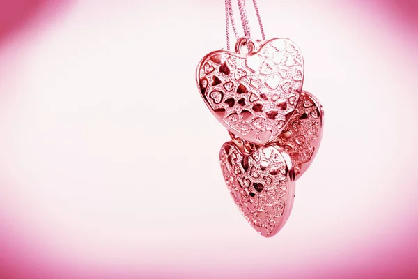 Heart on chain. Three pink hearts. Valentine's Day holiday. Pink hearts for lovers girls and women. — Stock Photo, Image