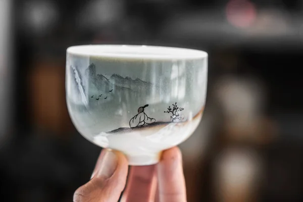 Chinese porcelain cup. Cup in a hand.