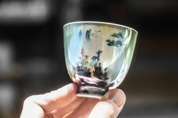 Porcelain cup. Hand holding cup.
