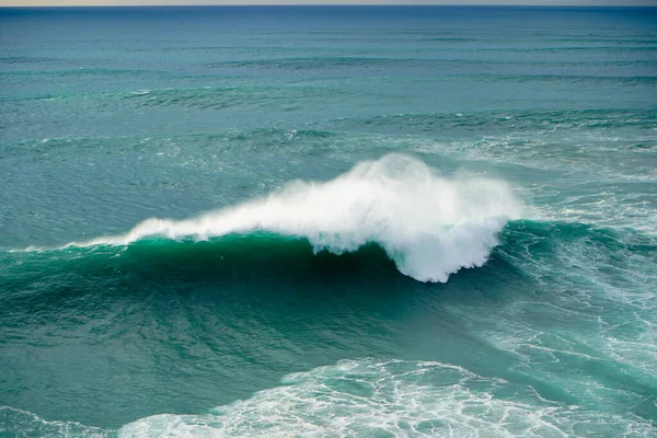 Big wave is breaking in the Atlantic ocean at Praia do Norte in Nazare, Portugal