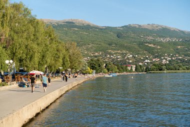 Ohri Gölü 'nün girişinde. İnsanlar gün batımında yürüyorlar. Ağustos 2019