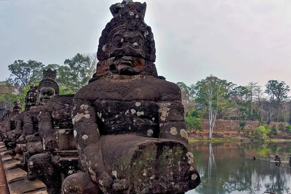 柬埔寨 河上桥上惊人的古代石雕 雕像的手中有一条长长的石蛇 他们脸上挂着神秘的微笑 — 图库照片