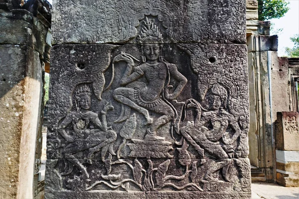 柬埔寨著名的吴哥寺柱子上的古代浮雕 三个Apsara舞者被描绘在运动中 脸上带着微笑 围绕着一个花卉装饰品 教科文组织遗产 — 图库照片