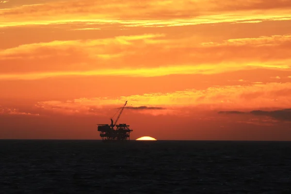 Plataforma de equipamento de petróleo durante o pôr do sol no Oceano Pacífico — Fotografia de Stock