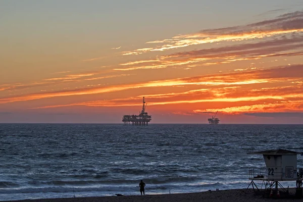 Plaży off-shore wiertniczym platformę o zachodzie słońca — Zdjęcie stockowe