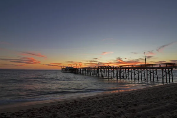 Puesta de sol de invierno de playa en Newport Beach, muelle y orilla de California — Foto de Stock