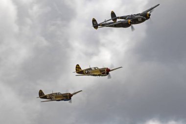 Hava gösterisi uçan uçak WWII P-40 Warhawks ve P-38 yıldırım vintage savaşçıları
