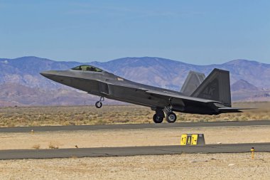 2018 Los Angeles Havacılık Fuarında performans uçak F-22 Raptor askeri stealth jet. Los Angeles, Kaliforniya, ABD / 23,2018 Mart. F-22 Raptor ile birlikte diğer askeri gerçekleştirir ve uçan sivil hareket eder.