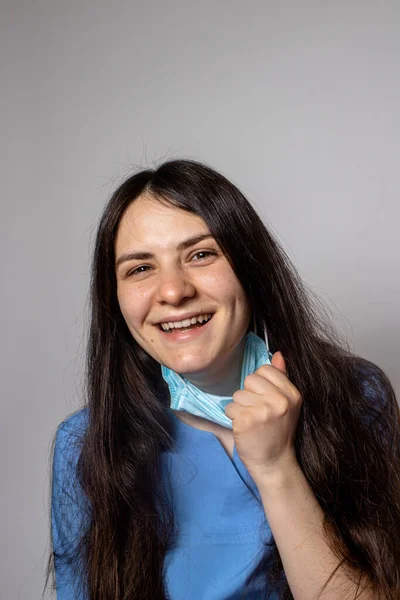 Woman doctor removes the mask from the face.