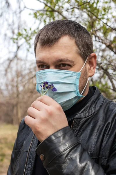 A man in a medical mask in the forest