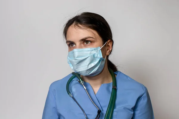 医生女士身穿蓝色制服 脖子上戴听诊器 — 图库照片
