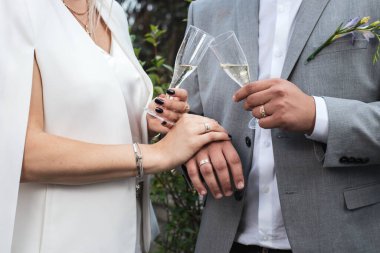 Gelin ve damat kadehlerini şampanya ile tutarlar.