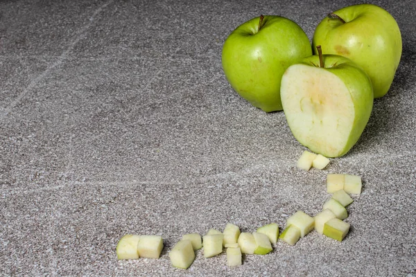 Green juicy apples Golden on a gray background. Diced apples.