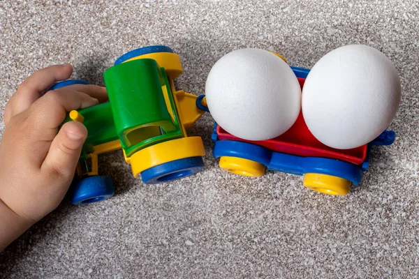 Niño Pequeño Juega Con Tractor Juguete Que Lleva Dos Huevos — Foto de Stock