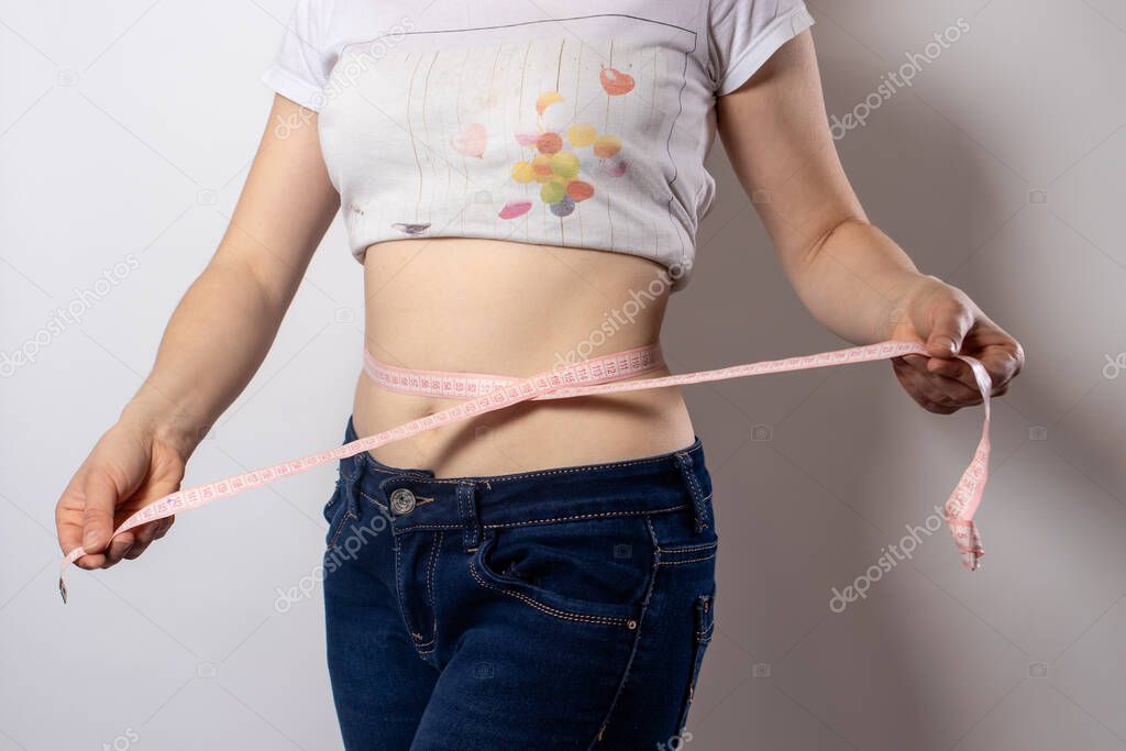 Measurement of the waist with a centimeter tape. Weight loss through proper nutrition, keto diets. Body detox and sports at home.