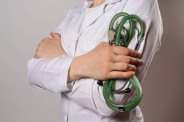 绿色听诊器 一名身穿白衣的医生拿着听诊器 — 图库照片