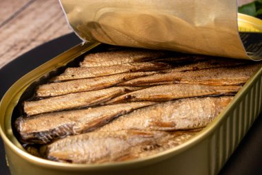 Sprats in oil. Smoked canned fish of sprat, herring and other small fish in oil. clipart