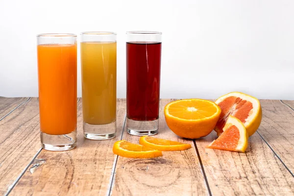 Tre Diversi Succhi Frutta Bicchieri Frutta Uno Sfondo Legno Nutrizione — Foto Stock