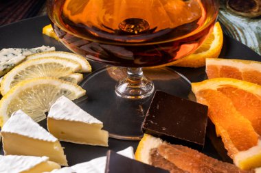 Atıştırmalık bir bardak konyak: Camembert peyniri, greyfurt, çikolata, limon, pahalı elit alkol.