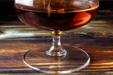 Konyak için bardağın bacağı. Koyu kahverengi arka planda sevgili seçkin alkol. Alkollü içecekler için tabaklar.