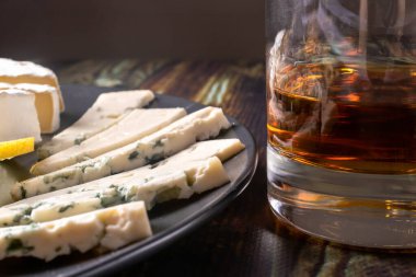 Bardakta viski ve aperatif. Mavi peynir ve peynir. Güçlü elit alkol ve atıştırmalık.