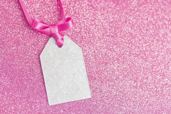 Pembe kurdeleyle bağlanmış boş bir etiket. Fiyat etiketi, hediye etiketi, satış etiketi, adres etiketi.