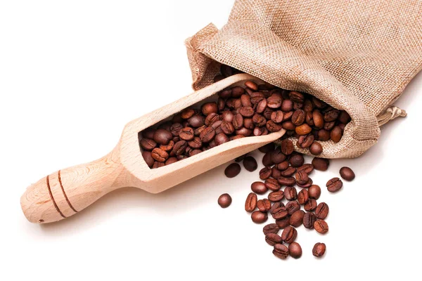 Keten çuvalında kahve çekirdeği ve beyaz arka planda ahşap kepçe.