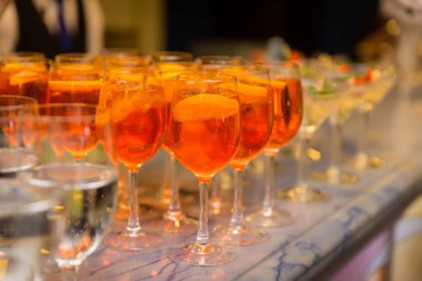 Masanın üzerinde bardakta Aperol spreyi var.