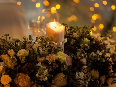 Çiçek aranjmanında duran güzel bir mum.