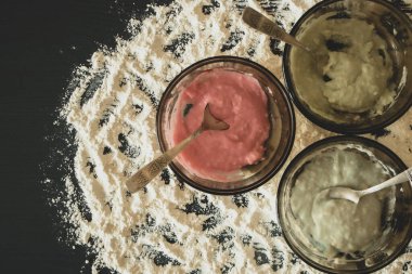 Renkli hamurlu üç kâsenin yakın plan fotoğrafı..