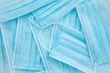 Mavi renkli birden fazla tıbbi maske. Parlak arkaplan.