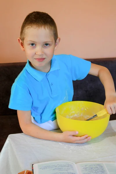 Little boy is preparing cupcakes. Funny and serious schoolboy prepares a dough and makes a delicious dessert. sit at home on isolation, what to play the child. #LockdownArt