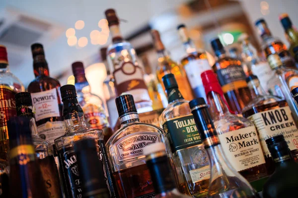 バーの棚の上のアルコール飲料の様々なボトル — ストック写真
