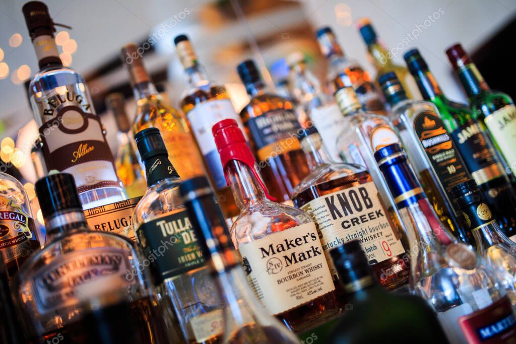 Various bottles of alcoholic beverages on the shelf in the bar