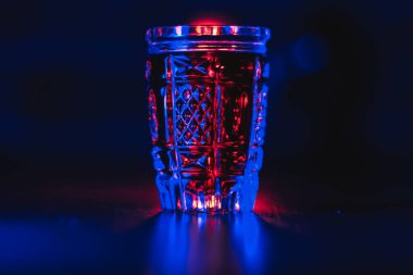 Neon ışıklı kristal bir bardakta kırmızı rengin tentürü