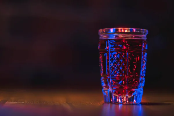 Tincture Red Color Crystal Glass Stands Wooden Table Blue Lighting — Stock Photo, Image