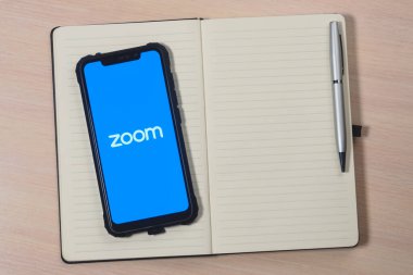 Ekran akıllı telefonundaki uygulama logosunu yakınlaştır. Zoom Video Communications, uzaktan konferans hizmeti veren bir şirket. Çevrimiçi toplantı için hazırlanılıyor.